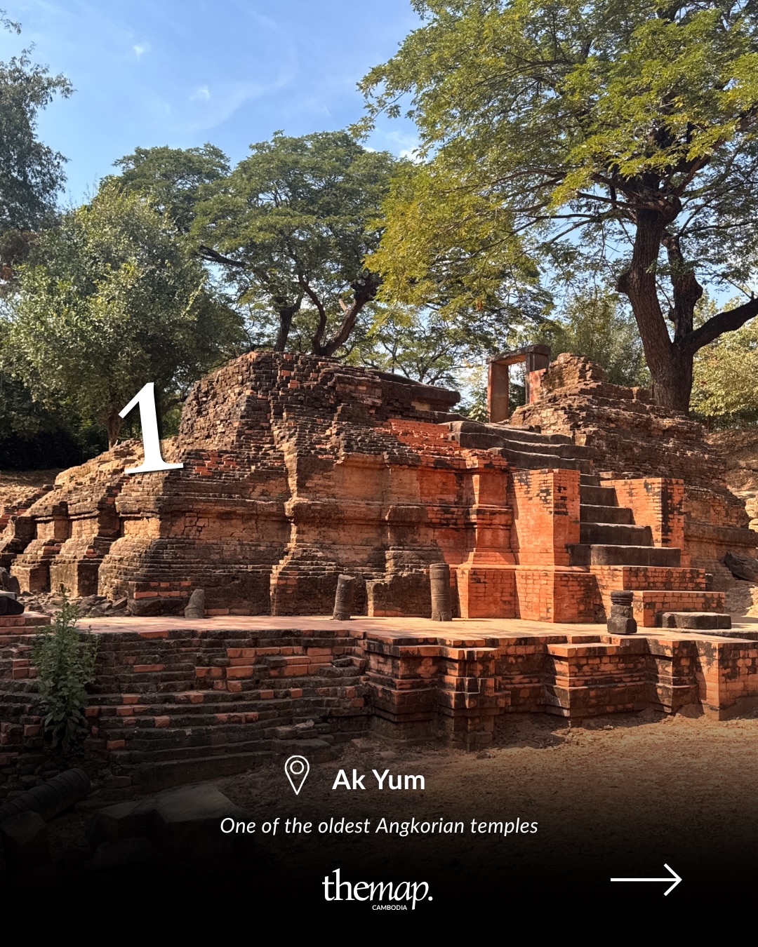 Red-brick ruins of Ak Yum temple shaded by trees near Siem Reap