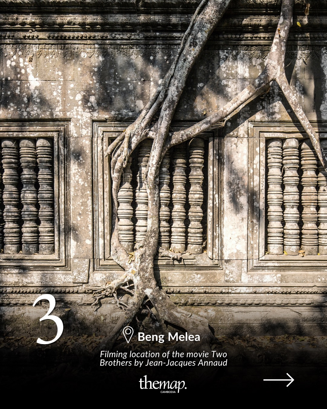 Carved sandstone window with tree roots growing across the wall at Beng Mealea
