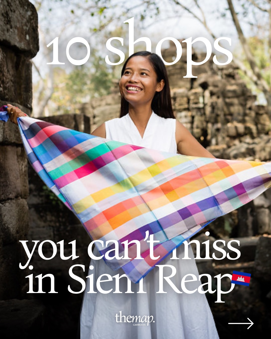 Woman holding a rainbow-checked handwoven silk scarf at a temple in Siem Reap