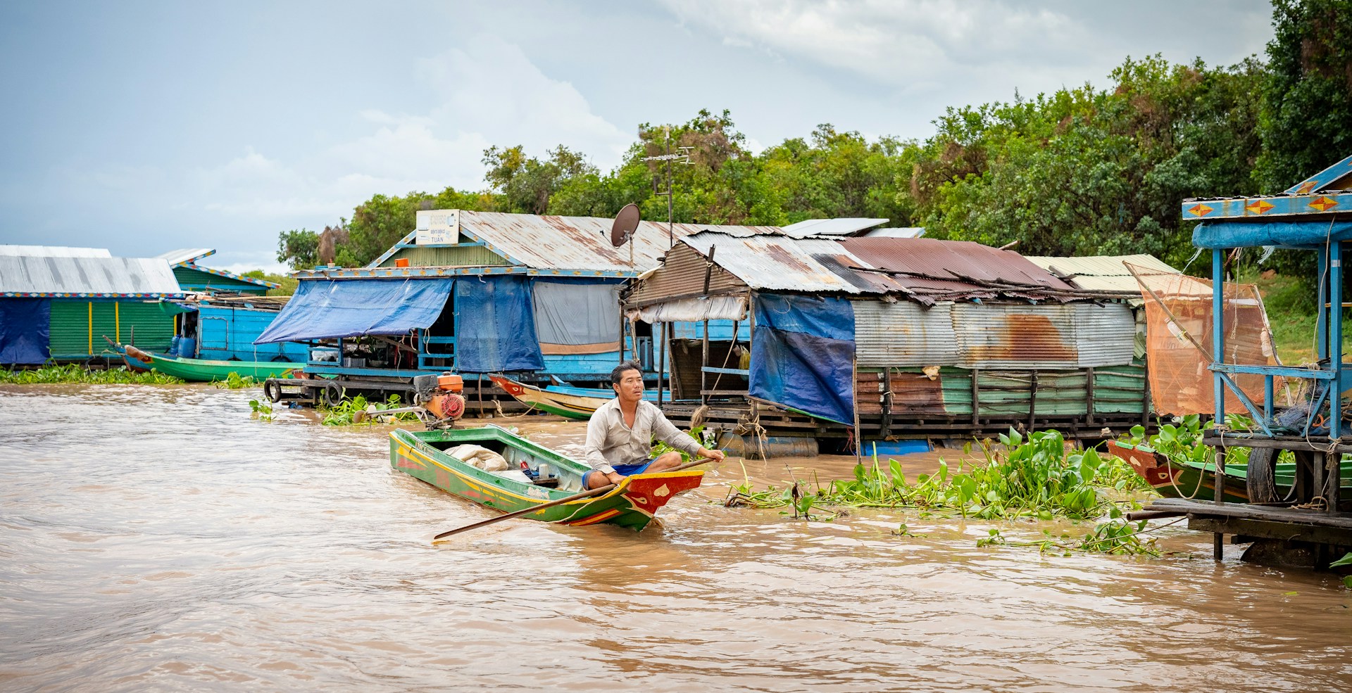 Barque et habitations au bord de l’eau à Kampong Khleang, sur le Tonlé Sap. Photo d’archive de 2019 ; le niveau de l’eau varie selon la saison.